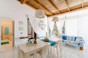 a dining room and living room with a table and chairs at Deliziosa Villa Patrizia a Otranto in Otranto