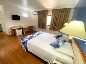a hotel room with a large bed and a desk at Hotel Dan Inn Sorocaba by Nacional Inn in Sorocaba