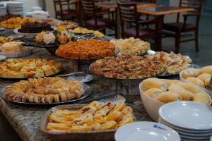 a table with many plates of food on it at Hotel Dan Inn Sorocaba by Nacional Inn in Sorocaba