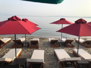a group of tables and umbrellas on a beach at Navarino Luxe Suites in Perea