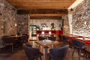 a restaurant with brick walls and tables and chairs at Hammerack Hotel, SPA & Wellness in Malborghetto Valbruna