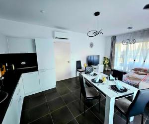 a kitchen and a living room with a table and chairs at Rose Garden Deluxe in Chernomorets