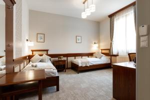 Pokój hotelowy z 2 łóżkami i biurkiem w obiekcie Hotel Kardosfa w mieście Zselickisfalud