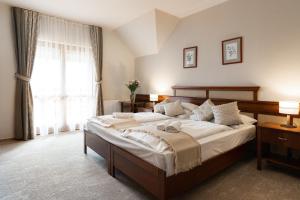 sypialnia z dużym łóżkiem i oknem w obiekcie Hotel Kardosfa w mieście Zselickisfalud