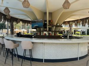 a bar in the middle of a resort with stools at Bright 2 Bedroom Apartment, Beach & Pool Access in Dubai