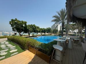 a swimming pool with tables and chairs in a resort at Bright 2 Bedroom Apartment, Beach & Pool Access in Dubai