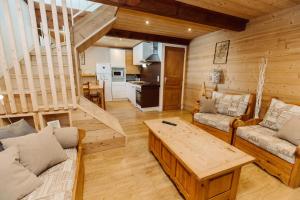 a living room with a couch and a table at ETERPA Les chalets de Pré Clos en Vercors in Saint-Andéol