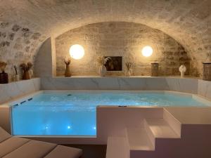 a large blue tub in a room with a stone wall at Hôtel Hiro Paris in Paris
