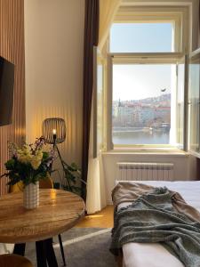 ein Schlafzimmer mit einem Tisch und einem Fenster in der Unterkunft Rašínovo nábřeží - Riverside Residence in Prag