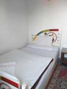 a white bed in a room with at Ziggy Marley Backpackers Hostel in Al Aqālitah