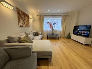 a living room with a couch and a flat screen tv at Ascot Stylish 3 Bedroom House with Driveway in Ascot