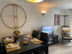 伦敦Lombok Apartment near Old Street,Islington,Angel的客厅配有桌子和墙上的大时钟