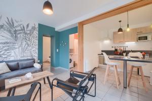 a living room with a couch and a table and chairs at La Marinière - Wifi - Bord de rivière in Laval
