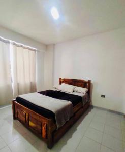ein Schlafzimmer mit einem Holzbett in einem Zimmer in der Unterkunft Comodidad y relax en Apartamento cerca del mar en Chichiriviche in Chichiriviche