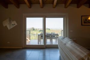 una sala de estar con una puerta corredera de cristal con una mesa en Tesoro Nascosto-Franciacorta UP, en Adro