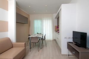 uma sala de estar com um sofá e uma mesa com cadeiras em Lungomare Relax Residence em Misano Adriatico
