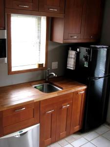 a kitchen with a sink and a black refrigerator at WildWoof Beach Bungalow - 3 Blocks to Beach in North Wildwood