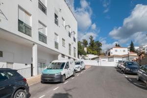 a row of parked cars parked next to a building at Villasur in Alcalá de los Gazules
