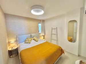 a bedroom with a bed with a yellow blanket at Appartement Eden A sanguinaires vue mer avec piscine résidence in Ajaccio