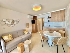 a living room with a couch and a table at Appartement Eden A sanguinaires vue mer avec piscine résidence in Ajaccio