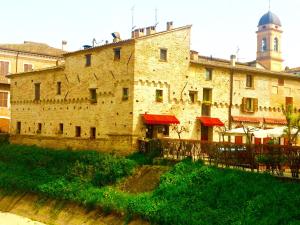 a large brick building with a clock tower on top at Locanda Delle Fate in San Giovanni in Marignano