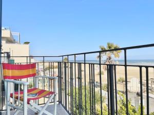 un balcón con una silla y la playa en Dimora storica con accesso privato alla spiaggia - Villa Drei, en Rímini