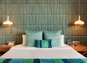a bedroom with a bed with blue and green pillows at The Park Visakhapatnam in Visakhapatnam