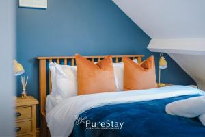 a blue bedroom with a bed with orange pillows at Incredible 5 Bedroom House with 7 actual Beds By PureStay - 3 min walk to Central Bath in Bath