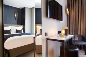 パリにあるホテル ル 10 BISのベッドとテーブルが備わるホテルルームです。
