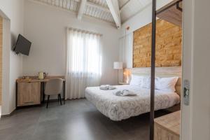 a bedroom with a bed and a desk with a computer at Oneira Rooms in Agrigento