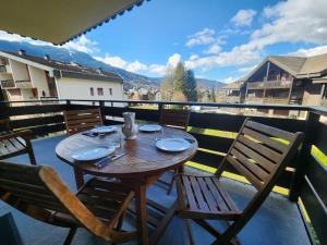 a wooden table and chairs on a balcony at Appartement 3 pièces avec wifi, 2 chambres, centre village - FR-1-629-101 in Samoëns
