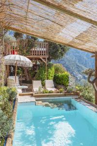 a swimming pool with a chair and an umbrella at POSEA Collection - Villa Ponente in Positano