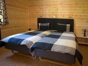 a bedroom with a large bed in a wooden room at Hamgården Nature Resort Tiveden in Tived