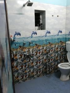 a bathroom with a wall of fish and dolphins at Aliya in Kolkata
