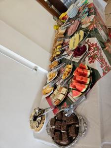 a bunch of different types of food on a table at Hotel Pousada Rolantchê in Rolante