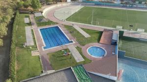 an overhead view of a swimming pool and a tennis court at Hostal R-Conecta in Cuevas de San Marcos