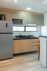 eine Küche mit weißen Geräten und Holzschränken in der Unterkunft Studio em Boa Viagem Excelente localização in Recife