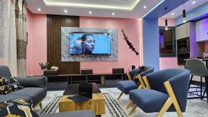 a living room with a tv on a pink wall at F2 équipé à Fann Hock in Dakar