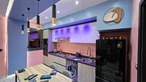 a kitchen with purple walls and a table and a sink at F2 équipé à Fann Hock in Dakar