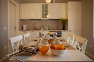 a kitchen with a table with a bowl of oranges on it at Dimora SWEET PIEVE in Erbusco