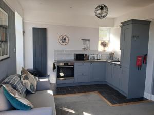 a living room with a couch and a kitchen at Eddystone Light Apartment in Mevagissey