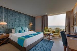 a hotel room with a bed and a desk and chairs at The Park Visakhapatnam in Visakhapatnam +37 photos