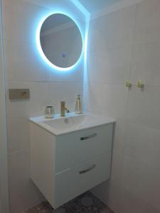 een witte badkamer met een wastafel en een spiegel bij Stare Miasto in Olsztyn