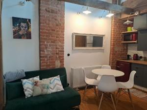 een woonkamer met een groene bank en een tafel bij Stare Miasto in Olsztyn +14 foto's