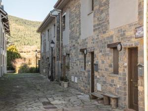 un edificio de ladrillo con un banco junto a una calle en Casa Arcangel, en Castiello de Jaca