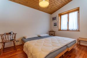 a bedroom with a large bed and a wooden ceiling at Ciasa al Sol in Falcade