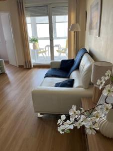 a living room with a white couch and a table at Vue Panoramique FACE MER in Bray-Dunes