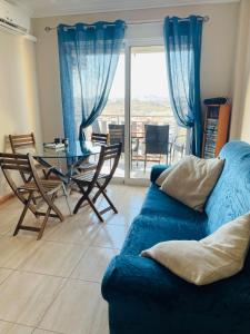 a living room with a blue couch and a table at La Bella Vista in Puerto de Mazarrón