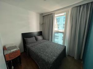 a small bedroom with a bed and a window at Flat em Santos no Gonzaga a três quadras da praia in Santos