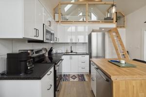 eine große Küche mit weißen Schränken und einer Leiter in der Unterkunft Harbour View Loft at Bells Cove in Shelburne + 9 Fotos